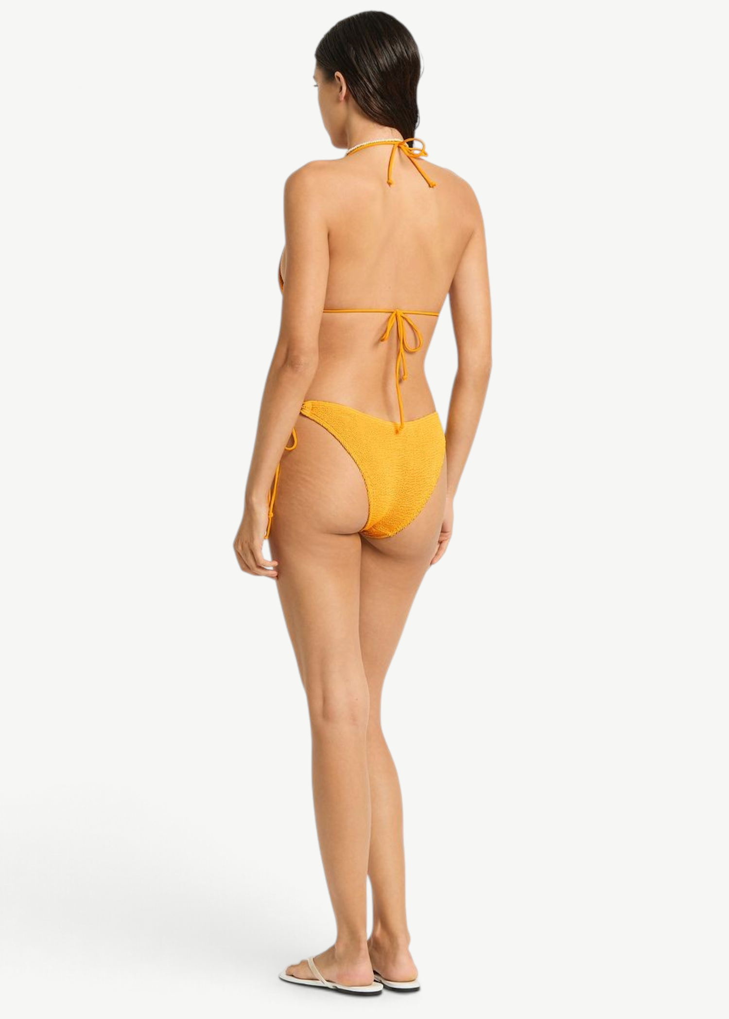 Model wearing KABE SHOP INC Sofie Tri mustard yellow textured bikini set with adjustable tie back from behind