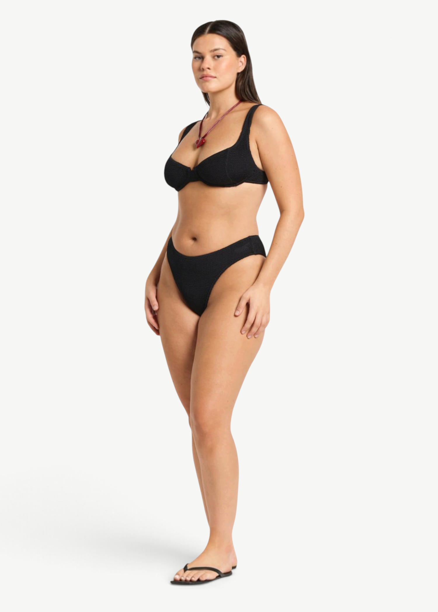 Model wearing KABE SHOP INC Olivia black high-cut bikini brief in shimmer crinkle fabric with full coverage
